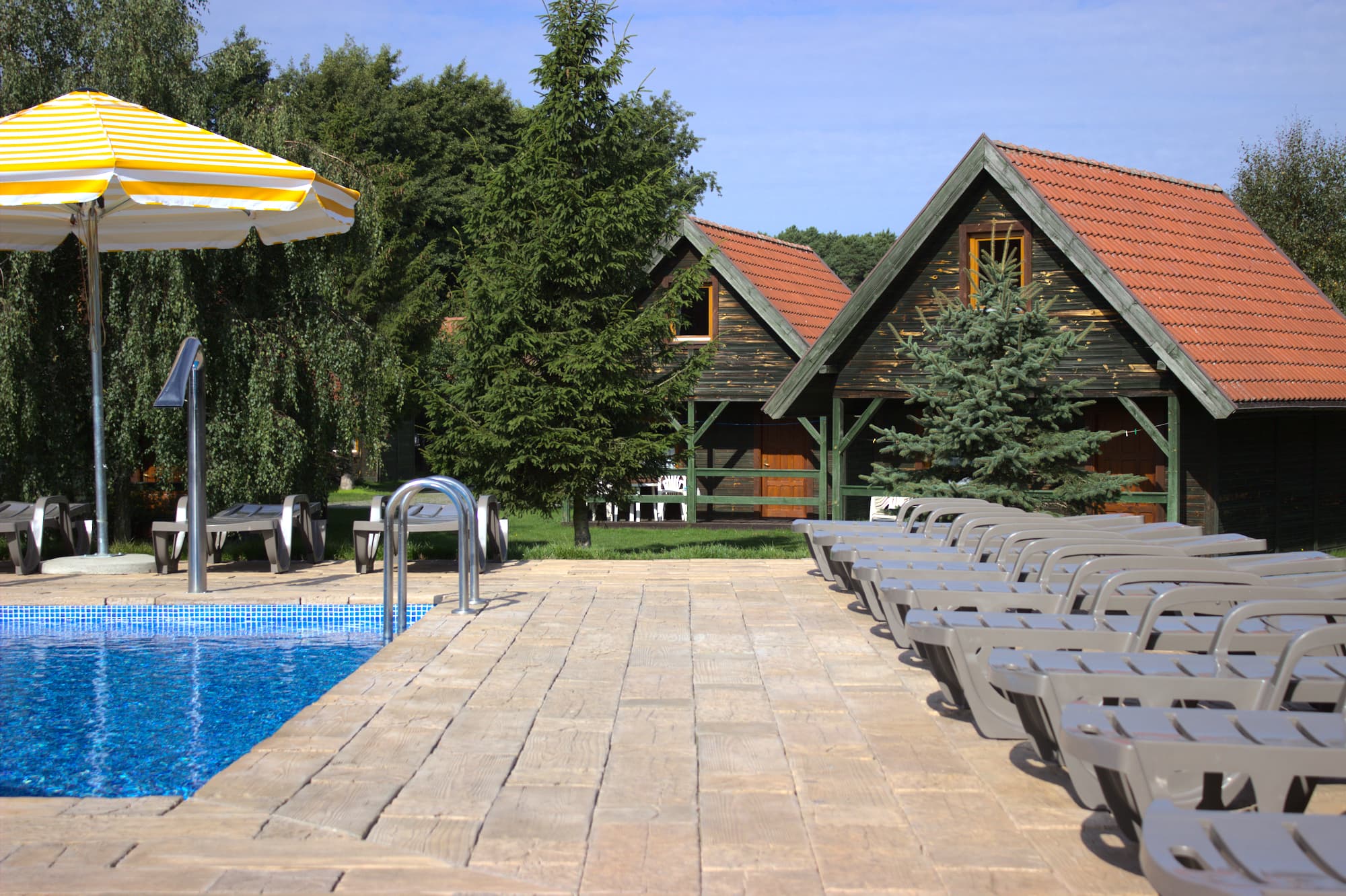 Bazén s chatkami v pozadí