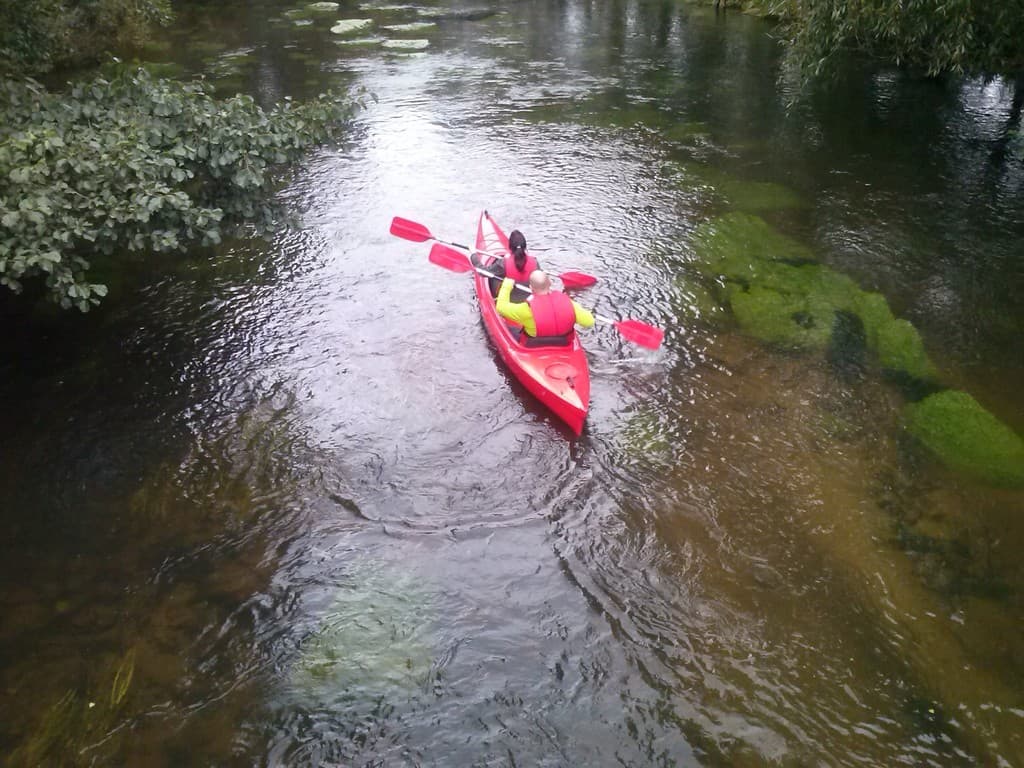 Family kayaking on the wild Chełst River near Łeba